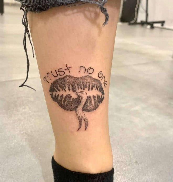 trust no one tattoo on leg